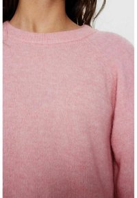 Ljusrosa tröja i mjukt material med ribbad rund halsringning och raglanärmar, med en slät och strukturerad finish.