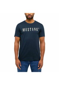 Granatowy bawełniany t-shirt z krótkimi rękawami i okrąg�łym dekoltem, z białym logo "MUSTANG" na piersi. Prosty design, bez wzorów.