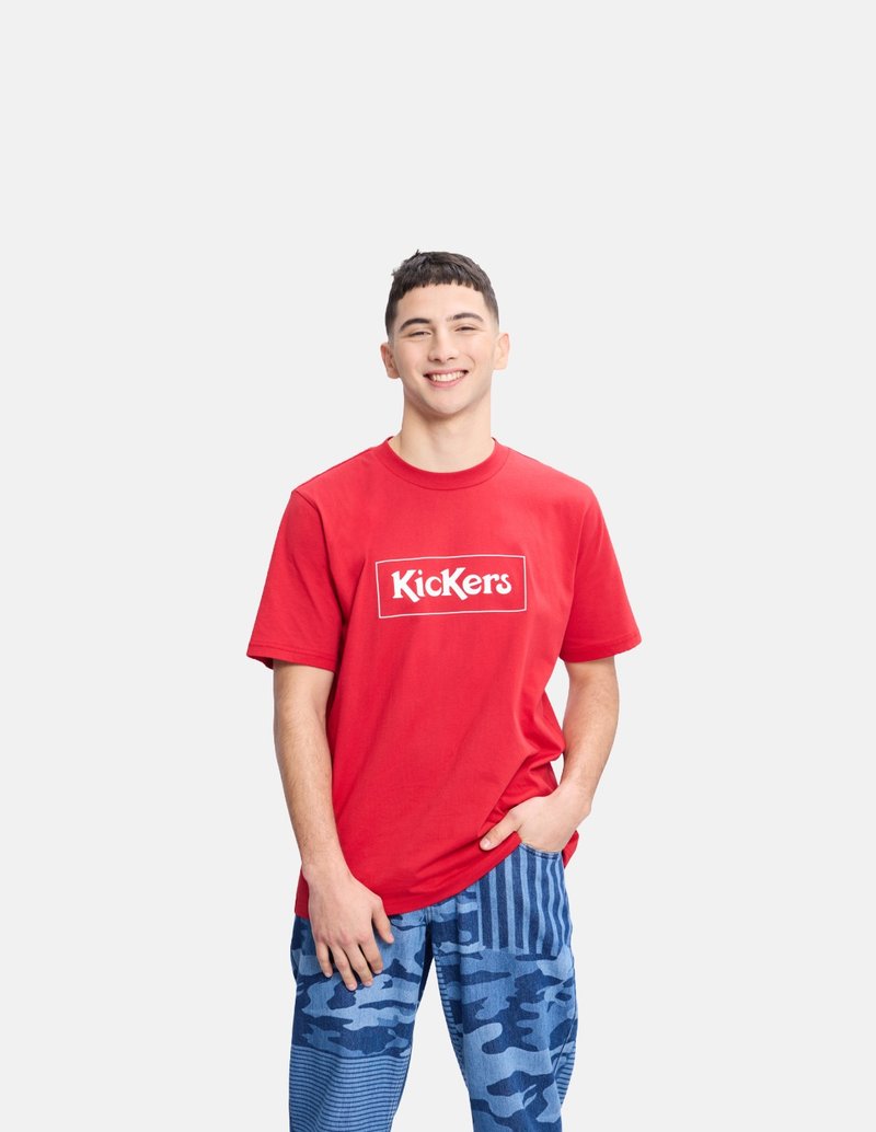 Camiseta de algodón roja con el logo de "Kickers", combinada con pantalones de camuflaje azul y rayas, que exhibe un corte relajado y patrones mezclados.