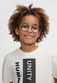 Barn iført en lys beige t-shirt med fed sort tekst, der står "UNITY" og "HUMANITY", suppleret med runde briller og krøllede hår.