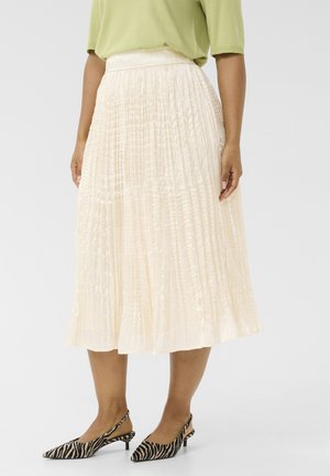 Pleated cream skirt with a textured finish, mid-length, and an elastic waistband, paired with black and white striped slingback heels.