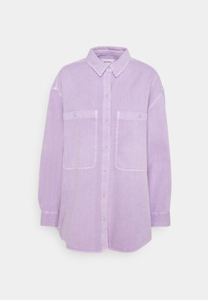Lys lilla oversized skjorte med lange ærmer, to brystlommer foran med knapklapper og en spids krave.