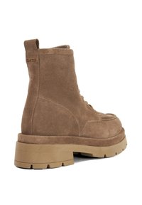 Brown suede ankle boot with a chunky beige sole, round toe, front lacing, and a pull tab at the back. Features stitching and logo detail.