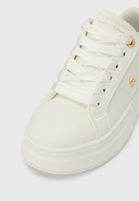 Weißer Ledersneaker mit flachen weißen Schnürsenkeln, abgerundeter Spitze und einer klobigen weißen Sohle. Verfügt über goldene Logodetails und Nahtakzente.