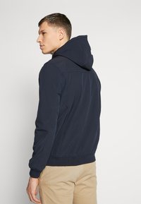 Marineblauwe hoodie met een gladde, flexibele stof. Voorzien van ribbelmanchetten en -zoom, platte naden en een strak ontwerp zonder zichtbare logo's.