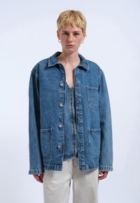 Giacca di jeans blu con chiusura a bottoni, colletto all'americana, due tasche frontali e maniche lunghe. Presenta cuciture leggere e una vestibilità comoda.