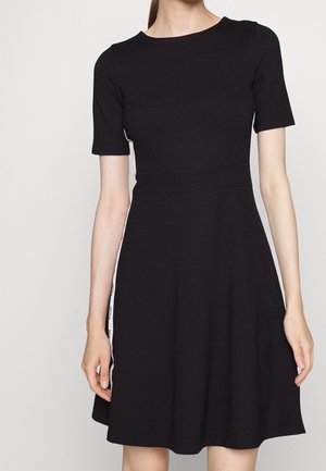 Zwart korte mouwen jurk met een getailleerde taille en een uitlopende rok, met witte zijpanelen en logo-tekst.