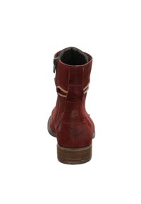 Botte de cheville en daim rouge avec un talon empilé marron, présentant une fermeture éclair sur le côté et deux accents en tissu horizontal à l'arrière. Doublure intérieure lisse.