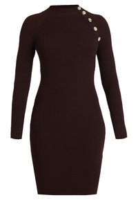 Robe en tricot côtelé bordeaux avec des manches longues et un col haut. Elle est dotée de boutons dorés décoratifs le long de l'épaule gauche. Coupe ajustée.