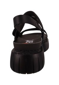 Sandalias negras con múltiples correas delgadas, plantilla contorneada y una suela gruesa y estriada para un buen agarre. Textura de cuero suave.