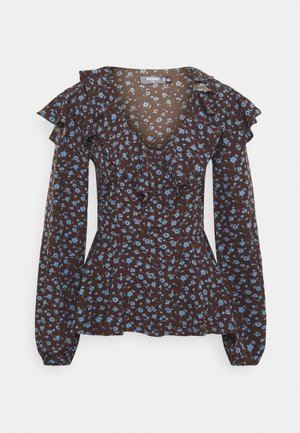 Brown floral blouse with blue flowers, ruffled neckline and sleeves, fitted waist, and long sleeves, made from lightweight fabric.