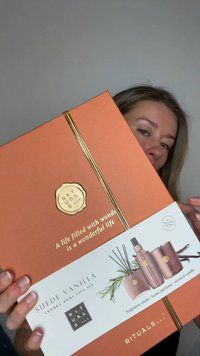 Pomarańczowe pudełko na prezent ze złotymi akcentami i pieczęcią. Zawiera zestaw zapachów do domu Suede Vanilla: patyczki zapachowe, buteleczkę perfum oraz świecę zapachową.