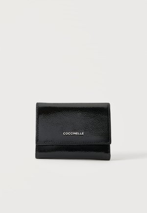 Sort blankt læderpung med klaplukning og sølv "COCCINELLE" logo centreret på forsiden mod en ensfarvet baggrund.
