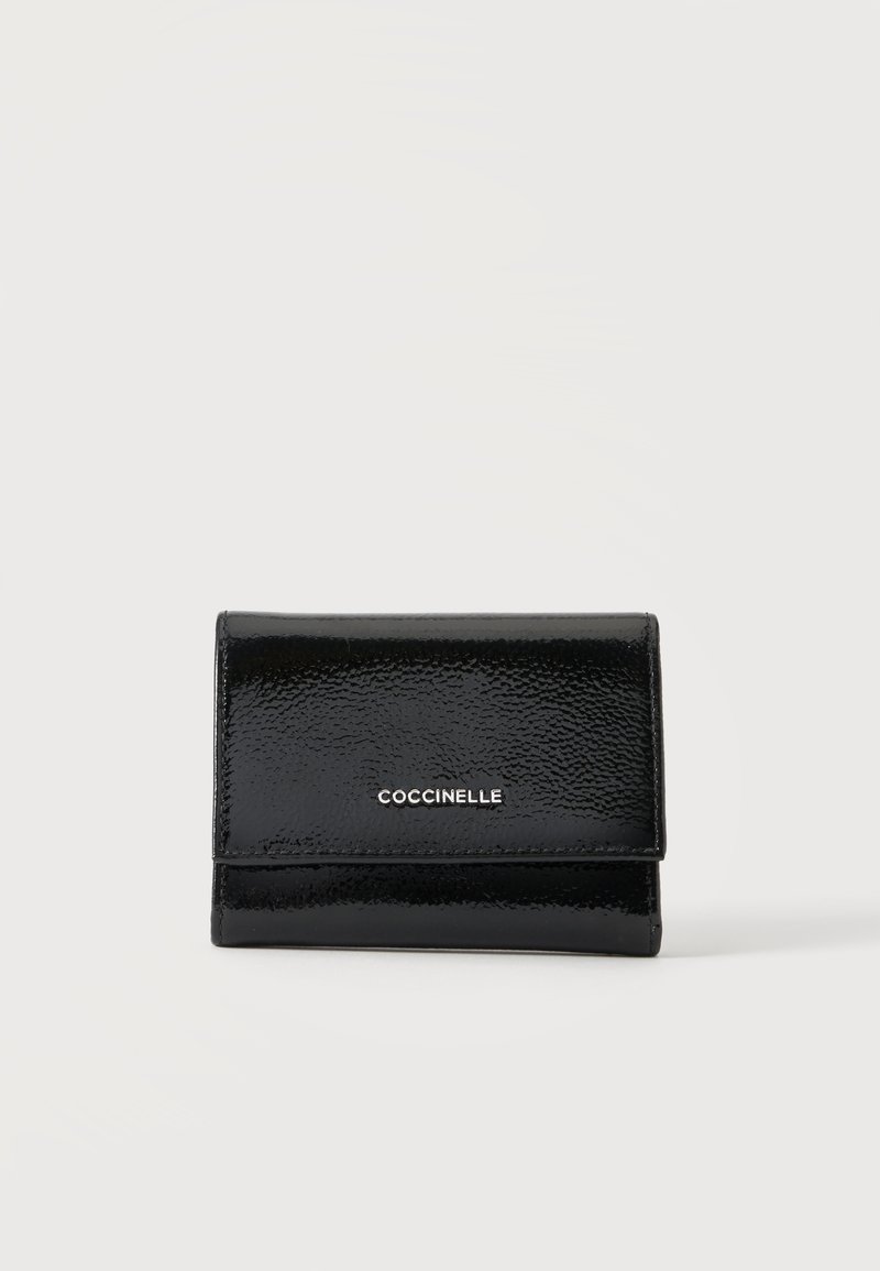 Portefeuille en cuir noir brillant avec une fermeture à rabat et un logo argenté « COCCINELLE » centré sur le devant sur un fond uni.