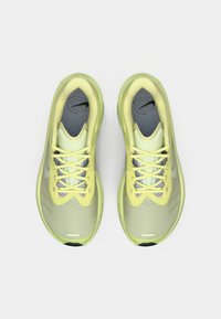 Πράσινα lime αθλητικά παπούτσια με διχτυωτό επάνω μέρος, γκρι εσωτερική επένδυση και ανακλαστικές λεπτομέρειες. Διαθέτουν κίτρινες κορδόνια και μαύρο λογότυπο στη φτέρνα.