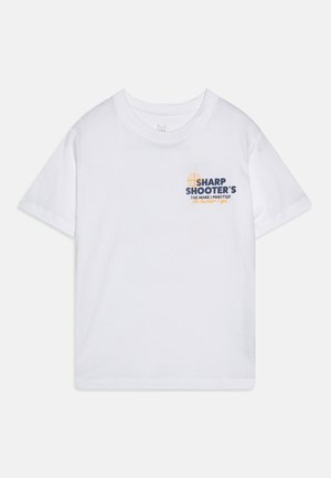 Balta kokvilnas T-kreklu ar īsām piedurknēm, apaļu kakla izgriezumu un priekšpusi ar grafiku zilā un apelsīnu krāsā, ar mērķa dizainu.