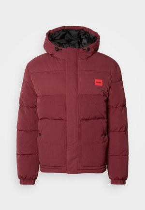 Chaqueta de invierno acolchada en color burdeos con capucha, bolsillos frontales con botones, puños elásticos y un pequeño parche rojo con el logo de HUGO en el pecho.