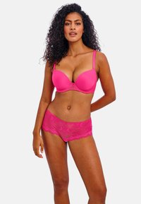Soutien-gorge rose rembourré avec dentelle et culottes roses assorties ornées de motifs floraux et d'un bord festonné, fabriqués en tissu doux.