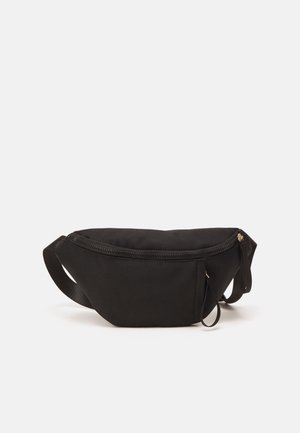 Musta nailonvyölaukku, jossa pyöreä muoto, vetoketjusuljin, säädettävä hihna ja kullanväriset metalliosat. Sileä pinta.