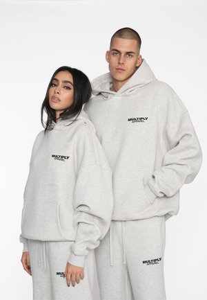 Gray cotton hoodies with large kangaroo pockets, featuring a contrasting black "MULTIPLY APPAREL" logo on the chest. Relaxed fit and textured.