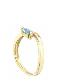 Zlatý prsteň s modrým drahokamom brúseným do tvaru marquise, upevneným dvoma cviklami, hladkým oblúkom, lešteným povrchom a viditeľnou pečaťou.