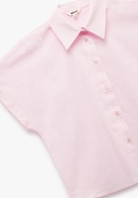 Camicetta rosa a maniche corte realizzata in tessuto leggero, con colletto a punte e chiusura frontale a cinque bottoni. Texture liscia.