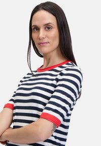 Stribet t-shirt med marineblå og hvide vandrette striber, rød ribben halsudskæring og manchetter, med en afslappet pasform og blød tekstur.