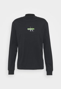 Svart långärmad polotröja i bomullsmix, med en grön och silverfärgad logga på bröstet och ribbade ärmslut.