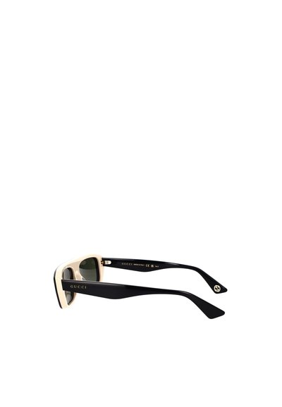 Occhiali da sole Gucci con una montatura nera e crema, forma rettangolare, lenti scure e marchio inciso sulle aste.