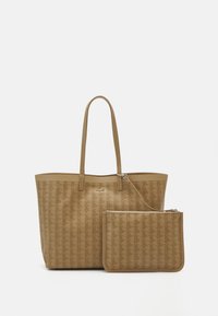 Sac fourre-tout beige avec motif géométrique en relief, deux longues anses, et une petite pochette assortie avec fermeture éclair, tous deux en matériau coordonné.