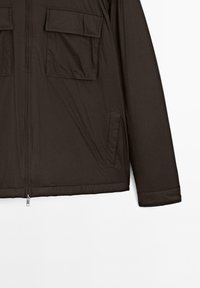 Dark brown jacket with front zipper, two chest flap pockets, and side welt pockets, shown from midsection to right sleeve.