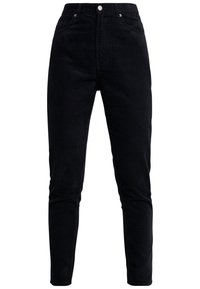 Pantalon en velours côtelé noir avec une taille haute, des jambes étroites et des coutures visibles, agrémenté de boutons métalliques et d'accents de fermeture éclair.