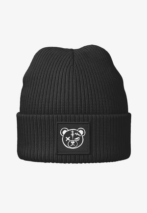 Black ribbed knit beanie with a folded cuff. Features a square patch with a white bear graphic, displaying stitches and expressive eyes.