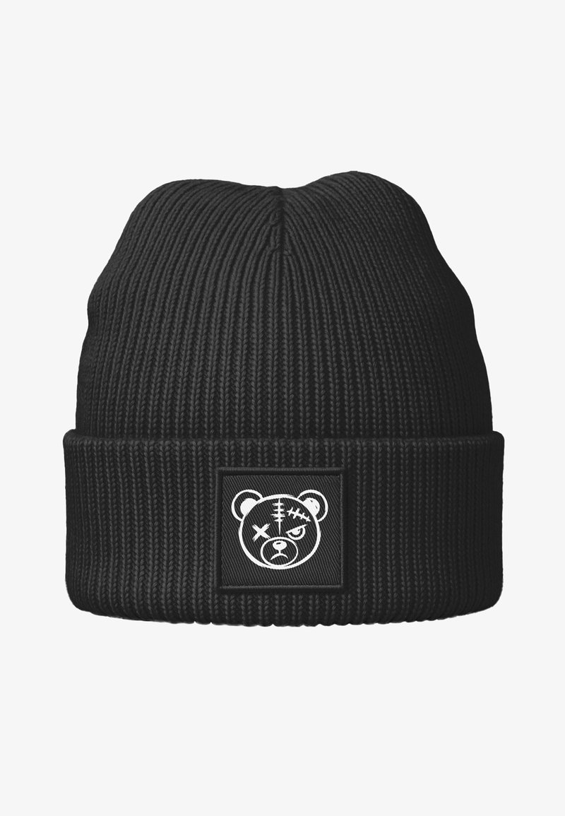Schwarze, gerippte Strickmütze mit umgeschlagenem Bündchen. Verziert mit einem quadratischen Aufnäher, der eine weiße Bärengrafik zeigt, mit sichtbaren Nähten und ausdrucksstarken Augen.