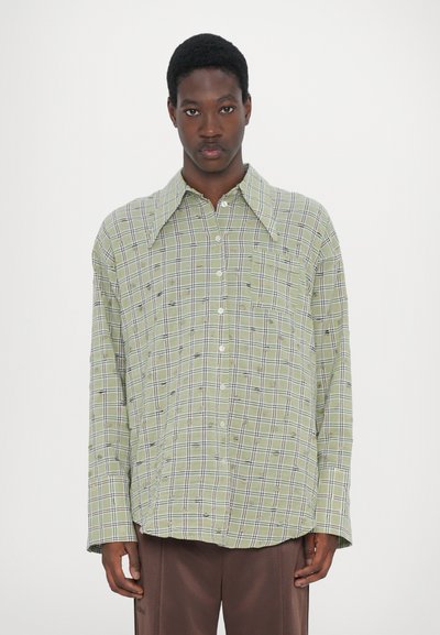 Green plaid button-up shirt with a wide collar, long sleeves, and a chest pocket. Features black and white grid lines throughout.