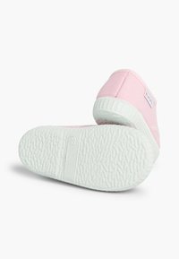 Scarpe in tela rosa con suola in gomma bianca testurizzata, dotate di un'etichetta cucita sul lato e un design a punta rotonda.