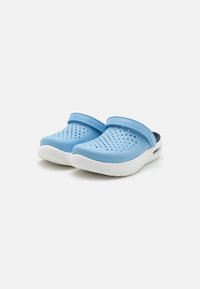 Light blue clogs with a perforated upper for ventilation, white soles, and a curved design. Features a raised strap for a secure fit.