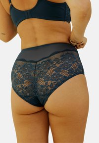 Culotte en dentelle bleu marine taille haute avec motif floral, accents en filet et tissu lisse. Doté d'un design sans couture pour le confort.