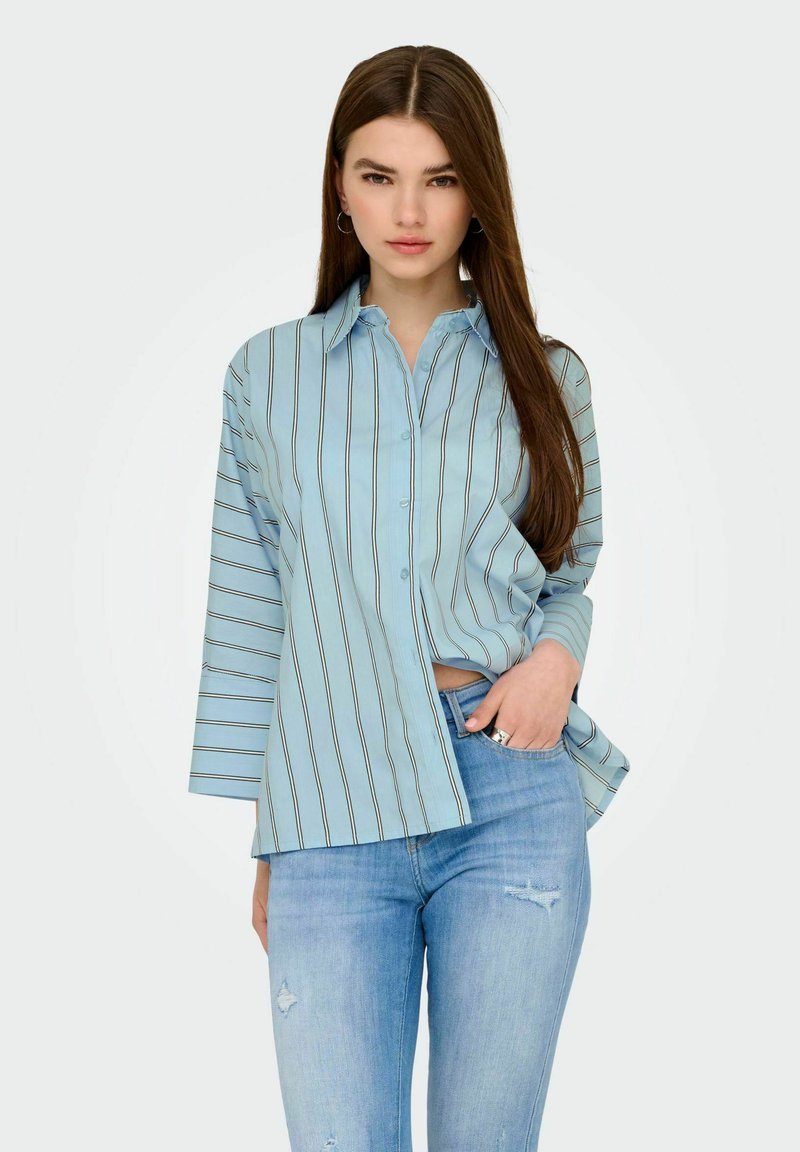 Camicia a maniche lunghe azzurro chiaro a righe, realizzata in tessuto liscio, con linee verticali in colori scuri e una vestibilità morbida.