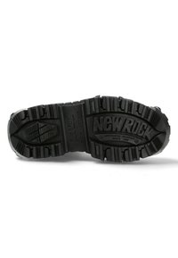 Black rubber boot sole with deep treads, featuring "NEW ROCK" embossed, rectangular and triangular patterns for traction and durability.
