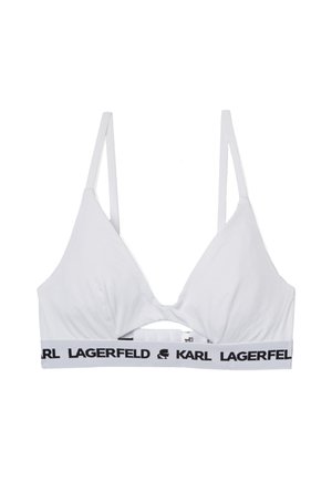 Bralette bianco con forma triangolare, dotato di una parte centrale con apertura e spalline sottili. Fascia con logo nero alla base. Il tessuto appare liscio.