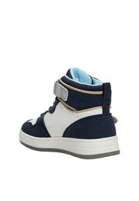 Baskets montantes bleu marine avec des accents blancs et argentés ; dotées d'une sangle Velcro et d'un matériau en suédine texturé. Semelle en caoutchouc avec motif de traction.