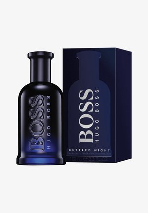 Mørk glasflaske med cylindrisk form, forsynet med hævede bogstaver. Følger med en mørkeblå boks med sølv-kant. 100 ml størrelse.