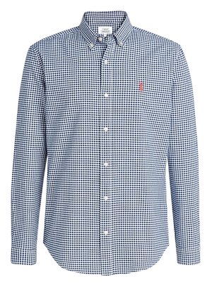 Chemise homme à manches longues boutonnée, à motif à carreaux bleu et blanc, avec un petit logo rouge brodé sur la poitrine.