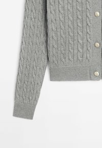 Gray cable-knit cardigan with a V-neck, ribbed cuffs and hem, and round, gold-tone buttons along the front placket.
