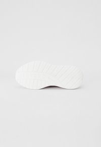 Semelle de chaussure blanche avec un motif de grip texturé. Légère courbure au niveau du talon, avec un logo en relief. Fini lisse avec un design globalement durable.