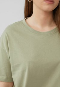 Olijfgrijze katoenen t-shirt met een ronde halslijn en korte mouwen, met een gladde textuur en minimale stikdetails.