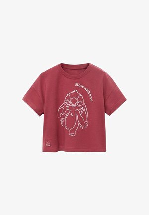 Chemise rouge à manches courtes avec un personnage de dessin animé blanc et le texte "Agir avec amour" en arc au-dessus du personnage.