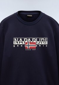 Marine blauwe crewneck sweatshirt met een witte opdruk van "NAPAPIJRI" en een kleine Noorse vlag, met "SINCE 1987" eronder. Zachte stof textuur.