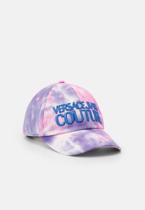 Tie-dye baseball cap in pink and purple with blue embroidered "Versace Jeans Couture" logo on front against white background.